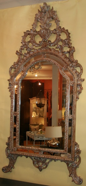 Ornately carved wood framed mirror in a silver finish