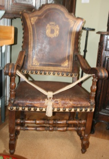 Rare early 18th century Continental armchair in original leather with an armorial design. Walnut wood frame.